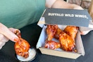 a person dipping wings in ranch