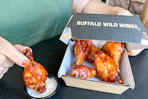 a person dipping wings in ranch