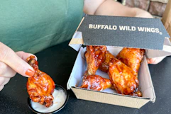 a person dipping wings in ranch
