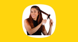 a woman using a hair straightener brush