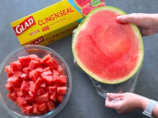 person pulling glad clin'n seal over halved watermelon to keep it fresh