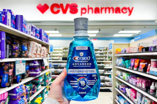 hand holding crest mouthwash in front of cvs pharmacy sign