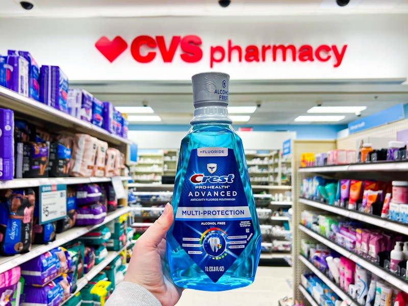 hand holding crest mouthwash in front of cvs pharmacy sign