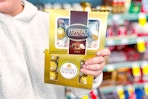 person holding 2 boxes of ferrero rocher chocolates