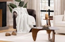 a white fur blanket on a chair in a living room