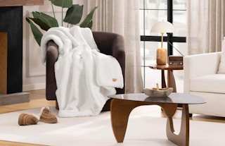 a white fur blanket on a chair in a living room