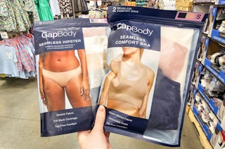 person holding a pack of gap underwear and a pack of bras