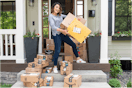 joanie holding amazon boxes on a porch