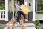 joanie holding amazon boxes on a porch