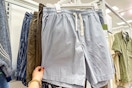 hand grabbing men's shorts off a target shelf