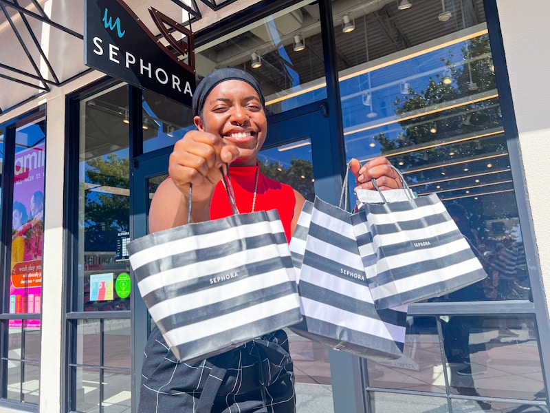 a person standing outside of sephora with shopping bag