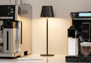 a cordless lamp next to a coffee machine