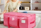 a person next to a pink moving bag