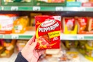 hand holding a pack of hormel pepperoni