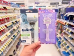 hand holding gillette and venus razors in walgreens