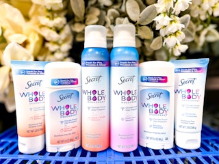Secret deodorant on top of a blue Walmart basket in front of flowers
