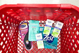 box of bar soap, shoe inserts, three boxes of toothpaste and a pack of razors in a shopping cart