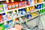 laundry detergent aisle and hand pushing a shopping cart