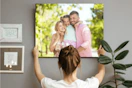 A woman hangs a large print in a room 