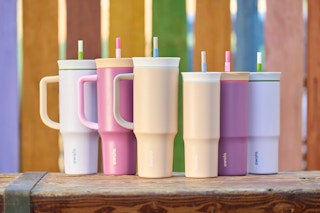 Three Owala 40 ounce tumblers on a wooden box next to three Owala 24 ounce tumblers.