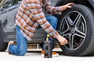 Lifestyle image of person using the Ophanie Tire Inflator Tool to inflate a car tire.