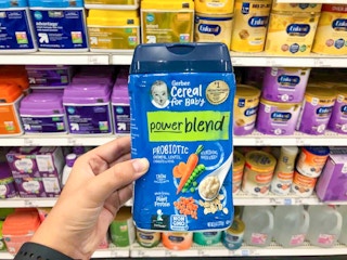 hand holding gerber powerblend cereal in front of a shelf of formula at target
