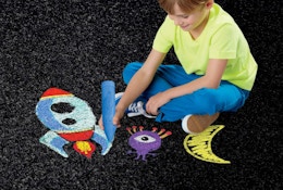 a kid coloring with chalk on a street