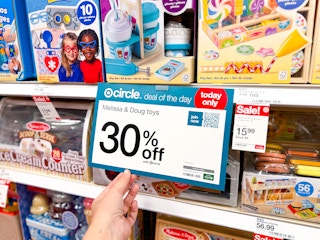 hand holding sale sign near melissa & doug toys at target