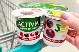 hand holding a pack of activia yogurt