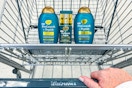 hand pushing a walgreens shopping cart with OGX progrowth hair care products