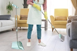 a woman using a broom and dustpan set