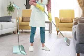 a woman using a broom and dustpan set