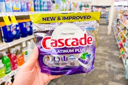 person holding a bag of cascade dishwasher pods