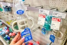 hand holding a dr. brown.s sippy bottle in front of a target sale tag