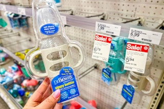 hand holding a dr. brown.s sippy bottle in front of a target sale tag
