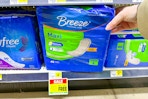 hand grabbing a pack of breeze maxi pads