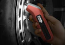 a tire pressure gauge being used on a tire