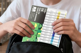 person pulling markers out of bookbag