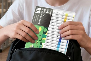 person pulling markers out of bookbag