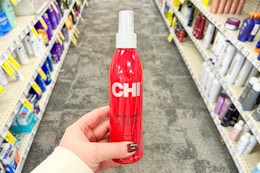 hand holding a bottle of chi thermal iron guard