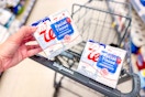 person placing a box of tissues in a cart