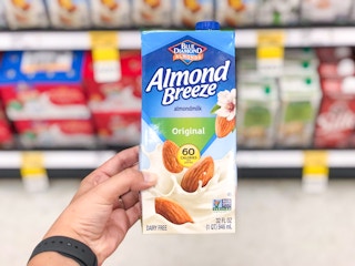 hand holding carton of almond milk in front of Target aisle