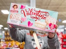 person holding a box of little debbie valentine cakes