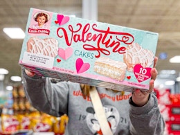 person holding a box of little debbie valentine cakes