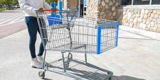 person pushing an empty walmart shopping cart