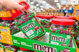 hand holding a jar of m&ms christmas candy