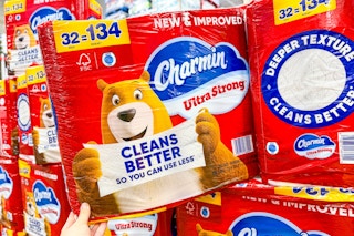 hand holding a pack of charmin toilet paper