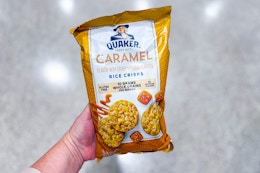 person holding a bag of quaker rice crisps