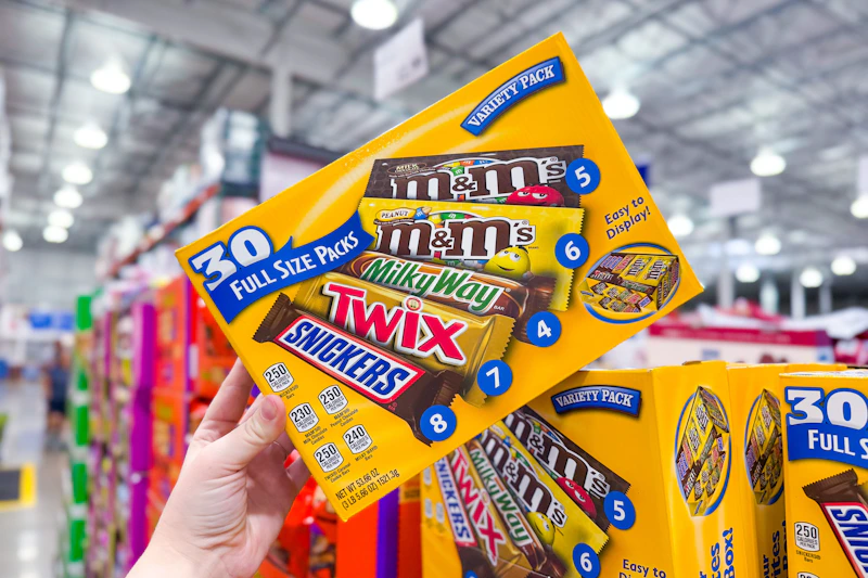 hand holding a box of mars candy bars