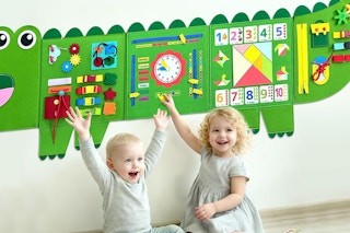 child playing with wall busy board